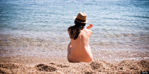 Beach day. Girl with long brown hair looking at the sea