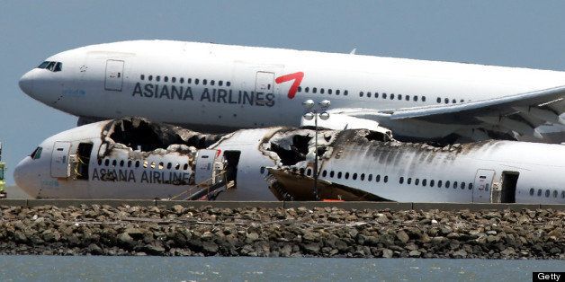 SAN FRANCISCO, CA - JULY 09: An Asiana Airlines flight lands next to the wreckage of Asiana Airlines flight 214 as it sits on runway 28L at San Francisco International Airport on July 9, 2013 in San Francisco, California. Three days after Asiana Airlines flight 214 crash-landed at San Francisco International Airport, the National Transportation Safety Board (NTSB) is continuing their investigation into why the plane crashed. (Photo by Justin Sullivan/Getty Images)