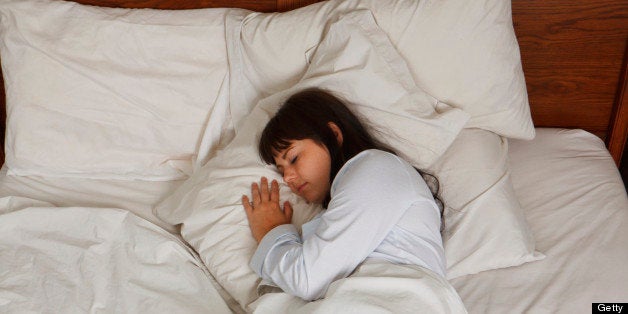 Young Woman Sleeping In Bed From Above