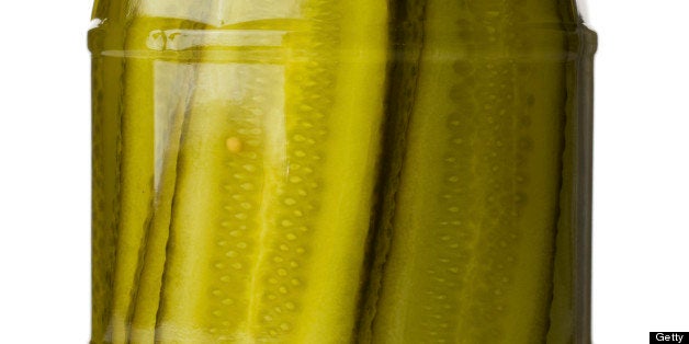 A jar of deli styled pickled gherkins (Cucumber) isolated on a white background.