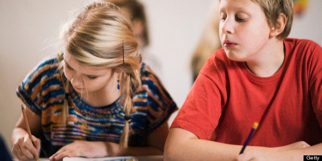 Schoolboy having a peep at what his classmate is writing Sweden.