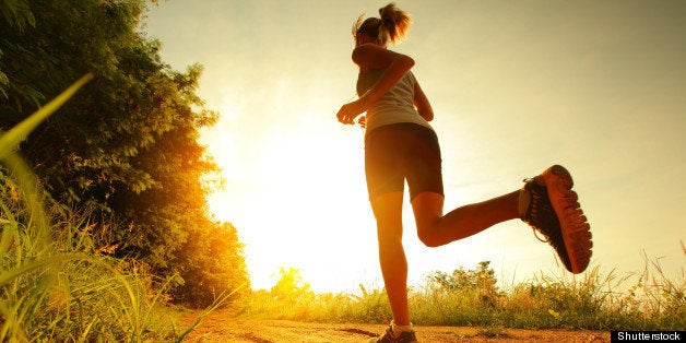 Young lady running on a rural road during sunset