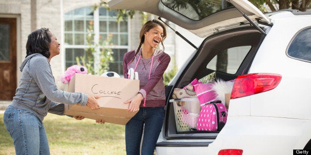 African American mother helping daughter pack for college