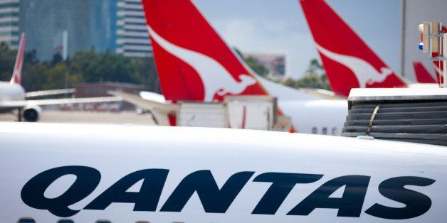 The Qantas Airways Ltd. signage and logo is displayed on aircraft at the domestic terminal of Sydney Airport in Sydney, Australia, on Tuesday, Feb. 19, 2013. Qantas Airways is scheduled to announce half-year earnings on Thursday, Feb. 21. Photographer: Ian Waldie/Bloomberg via Getty Images 