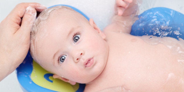 5 month old baby boy bathing and enjoying getting his hair washed