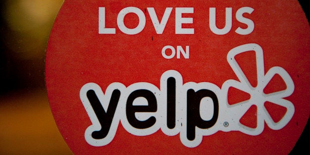 The Yelp Inc. logo is displayed in the window of a restaurant in New York, U.S., on Thursday, March 1, 2012. Yelp Inc., the site that lets users review everything from diners to dentists, is set to price it's IPO tonight and could potentially raise as much as $100 million, which would value the company at about $838 million. Photographer: Scott Eells/Bloomberg via Getty Images