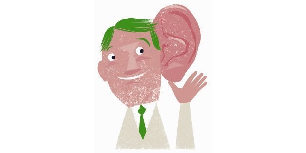 Smiling businessman listening with enormous ear