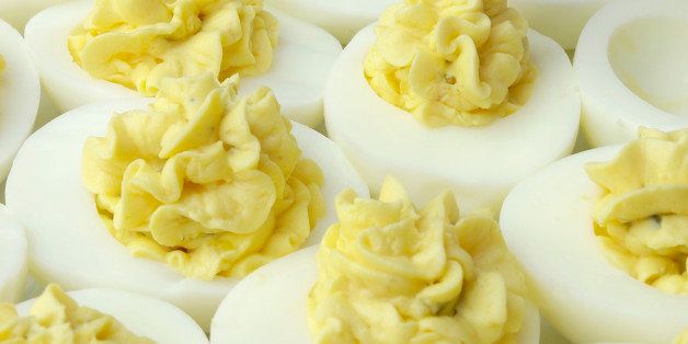 Chef fills deviled eggs using piping bag.