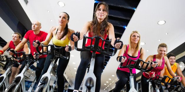 Low angle view on a spinning class in the gym with a group of people attending it.