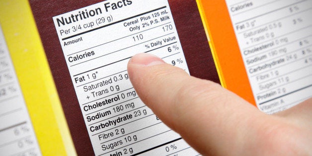 A concerned shopper checks the nutrition labels of various boxes of cereal.