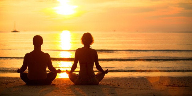 young couple practicing yoga on ...