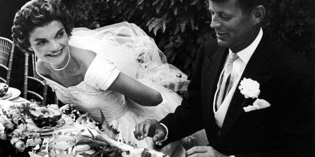 NEWPORT, UNITED STATES - SEPTEMBER 01: Senator John Kennedy and bride Jacqueline sitting together outdoors at table, eating pineapple salad ,at their wedding reception. (Photo by Lisa Larsen/Time & Life Pictures/Getty Images)