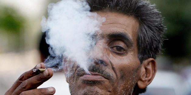 New Delhi, INDIA: An Indian man smokes a 'bidi?, a leaf hand-rolled with tobacco in New Delhi, 31 May 2007,on World No-Tobacco day.Two-thirds of the planet's adult smokers live in 15 low-income or middle-income nations, nearly half of them in only five: China, India, Russia, Indonesia and Bangladesh. AFP PHOTO/ MANAN VATSYAYANA (Photo credit should read MANAN VATSYAYANA/AFP/Getty Images)
