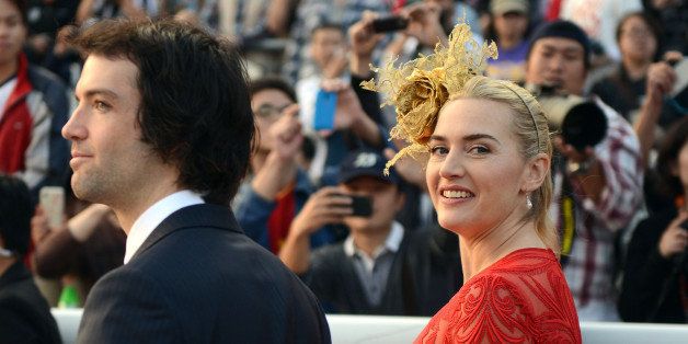 (FILES) In a file picture taken on December 9, 2012 British actress Kate Winslet (R) and boyfriend Ned Rocknroll (L) walk together after the presentation ceremony for the 2,000-metre Longines Hong Kong Cup race at the Hong Kong International Races at the Shatin racecourse in Hong Kong. Oscar-winning actress Kate Winslet has married her third husband in a secret ceremony -- tying the knot with Richard Branson's nephew Ned RocknRoll, The Sun tabloid reported on December 27, 2012. AFP PHOTO / ANTONY DICKSON (Photo credit should read ANTONY DICKSON/AFP/Getty Images)