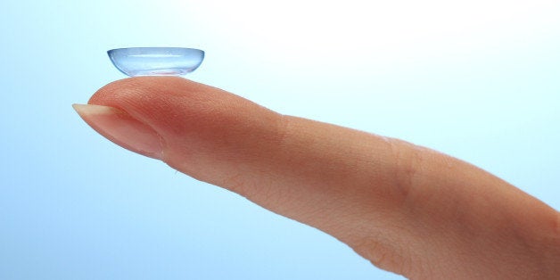 contact lens on finger on blue...