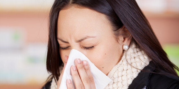 young woman with a cold using...