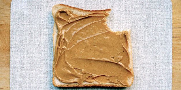 A missing bite from a slice of bread with peanut butter