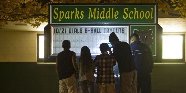 A family takes a photo of a memorial after a shooting at Spark Middle School in Sparks, Nevada, on Monday, October 21, 2013. (Hector Amezcua/Sacramento Bee/MCT via Getty Images)