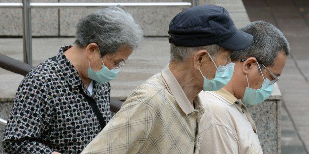 Three people wearing masks walk outside the National Taiwan University Hospital in Taipei on April 25, 2013. International experts probing China's deadly H7N9 bird flu virus said on April 24 it was 'one of the most lethal influenza viruses' seen so far as Taiwan reported the first case outside the mainland. AFP PHOTO / Sam Yeh (Photo credit should read SAM YEH/AFP/Getty Images)