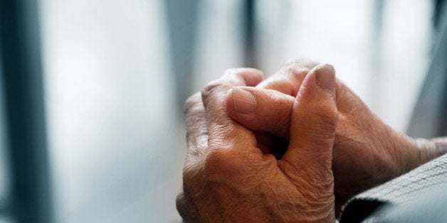 old woman's hands clasped...