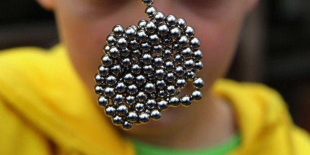 Brandon Bruski, 9, holds dozens of Buckyballs on Thursday, April 11, 2013 in Crystal Lake, Illinois. In January, Brandon accidentally swallowed two balls from this set of the small magnetic desk toys. The magnets left Brandon with a small and large intestine bound together. Emergency surgery was required. (Chris Sweda/Chicago Tribune/MCT via Getty Images)