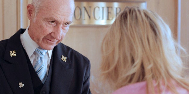 French Stephane Fanciulli, chief concierge of the Intercontinental Carlton Hotel, gives directions to a customer at the recep