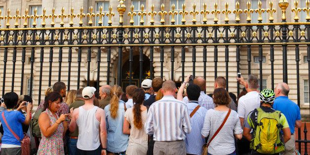 LONDON, UNITED KINGDOM - JULY 23: (EMBARGOED FOR PUBLICATION IN UK NEWSPAPERS UNTIL 48 HOURS AFTER CREATE DATE AND TIME) Tourists and members of the public crowd around the gates of Buckingham Palace to view an easel displaying the official document announcing the birth of a baby boy to the Duke and Duchess of Cambridge at the Lindo Wing of St Mary's Hospital on July 23, 2013 in London, England. (Photo by Max Mumby/Indigo/Getty Images)