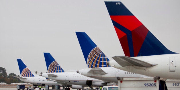 United Continental Holdings Inc. airplanes line up alongside a Delta Air Lines Inc. airplane on the tarmac at San Diego International Airport in San Diego, California, U.S. on Thursday, Sept. 19, 2013. Airlines must reconsider buying new or used aircraft as rising interest rates increase ownership costs, which could outweigh fuel savings at lower prices. Photographer: Sam Hodgson/Bloomberg via Getty Images