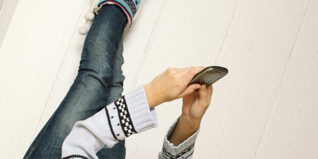 young woman lying at home on...