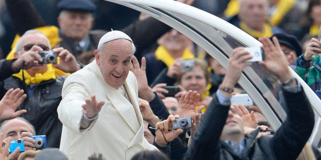 Pope Francis greets the crowd as he arrives for his general audience at St Peter's square on January 22, 2014 at the Vatican. AFP PHOTO / ANDREAS SOLARO (Photo credit should read ANDREAS SOLARO/AFP/Getty Images)