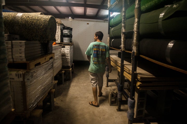 Kendall Rickard walks through the warehouse of Southland Flooring and Design, where he and Rhoda placed all products on cinde