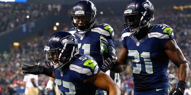 SEATTLE, WA - JANUARY 19: Outside linebacker Malcolm Smith #53 and strong safety Kam Chancellor #31 celebrate after Smith intercepts a pass in the endzone to win the game for the Seahawks against the San Francisco 49ers during the 2014 NFC Championship at CenturyLink Field on January 19, 2014 in Seattle, Washington. (Photo by Jonathan Ferrey/Getty Images) 