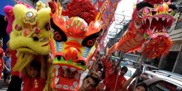 Members of the Chinese community perform a traditional dragon and lion dance in the street of China Town in Manila on February 13, 2010, at the eve of the Lunar New Year heralding the Year of the tiger. Chinese people around the world celebrate Lunar New Year. AFP PHOTO/JAY DIRECTO (Photo credit should read JAY DIRECTO/AFP/Getty Images)
