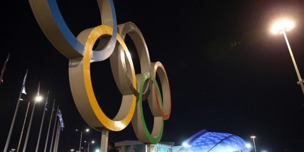 People walk by the Fisht Olympic Stadium before the start of the Opening Ceremony of the Sochi Winter Olympics on February 7, 2014 in Sochi. AFP PHOTO / LOIC VENANCE (Photo credit should read LOIC VENANCE/AFP/Getty Images)