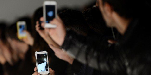 People use smartphones to photograph the Nicholas K show during the Mercedes-Benz Fashion Week Fall 2013 collections on February 7, 2013 in New York. AFP PHOTO/Stan HONDA (Photo credit should read STAN HONDA/AFP/Getty Images)