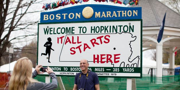 HOPKINTON, MA - APRIL 15: Katha Diddel of Greenwich, Conn., left, takes a photo of David Sussman of New York City at the start line area. Diddel and Sussman ran the New York City Marathon, and Diddel is running Boston. Runners and visitors hang around the start line the day before the Boston Marathon in Hopkinton, Mass. on Sunday, April 15, 2012. (Photo by Yoon S. Byun/The Boston Globe via Getty Images)