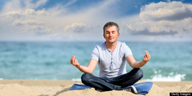 peaceful man making yoga on beach.