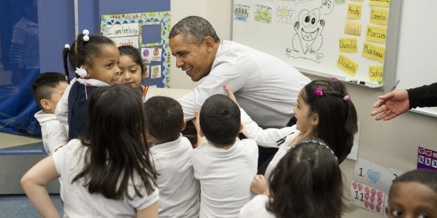 US President Barack Obama is helped up from the floor by children as he tours a Pre-K classroom at Powell Elementary School prior to speaking on the Fiscal Year 2015 budget in Washington, DC, March 4, 2014. The White House projected a steady fall in the US deficit over the next decade while the economy grows moderately, as it released its budget for the 2015 fiscal year on Tuesday. The budget foresees the American economy growing by 3.1 percent this year and by 3.4 percent the next, with inflation remaining under control, rising to only 2.0 percent in 2015.AFP PHOTO / Saul LOEB (Photo credit should read SAUL LOEB/AFP/Getty Images)