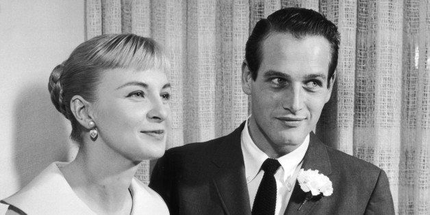 29th January 1958: American actors Joanne Woodward, wearing a pale-colored dress with a pleated skirt, and Paul Newman, wearing a suit and tie, holding a knife together as they prepare to cut into their wedding cake, Las Vegas, Nevada. (Photo by Hulton Archive/Getty Images)