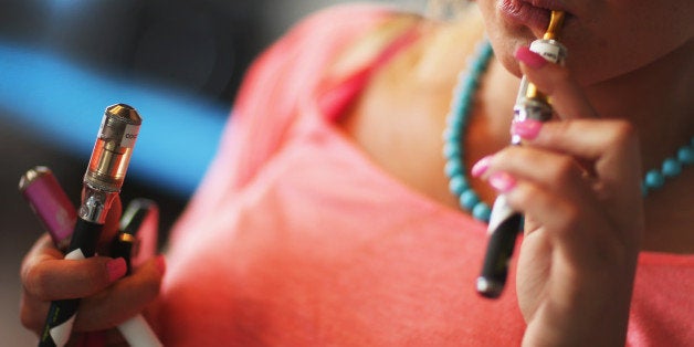 MIAMI, FL - SEPTEMBER 06: Chloe Lamb tries a flavor of E liquid in her electronic cigarette as she shops for a flavor at the Vapor Shark store on September 6, 2013 in Miami, Florida. E-cigarette manufacturers have seen a surge in popularity for the battery-powered devices that give users a vapor filled experience with nicotine and other additives, like flavoring. (Photo by Joe Raedle/Getty Images)