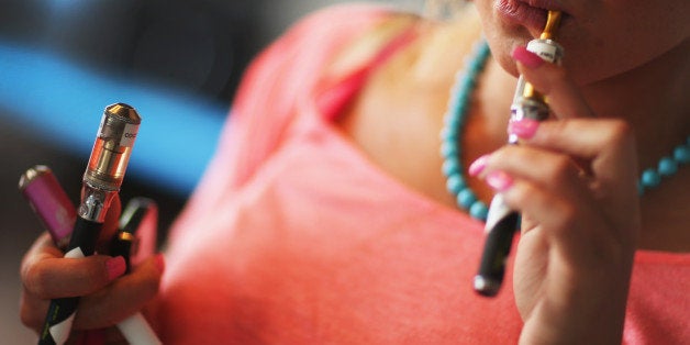 MIAMI, FL - SEPTEMBER 06: Chloe Lamb tries a flavor of E liquid in her electronic cigarette as she shops for a flavor at the Vapor Shark store on September 6, 2013 in Miami, Florida. E-cigarette manufacturers have seen a surge in popularity for the battery-powered devices that give users a vapor filled experience with nicotine and other additives, like flavoring. (Photo by Joe Raedle/Getty Images)