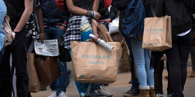 Pedestrians hold Primark branded shopping bags as they wait to cross a road on Oxford Street in London, U.K., on Thursday, April 3, 2014. Bank of England Governor Mark Carney wants to avoid stifling the recovery and the Monetary Policy Committee has said it won't consider raising its key rate at least until unemployment falls to 7 percent and some of the slack in the economy has reduced. Photographer: Simon Dawson/Bloomberg via Getty Images