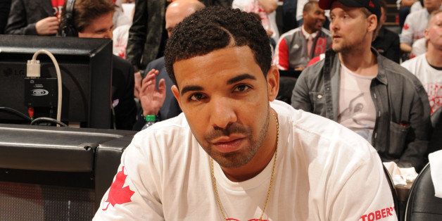 TORONTO, CANADA - April 19: Drake sits on the sideline during Game One of the Eastern Conference Quarterfinals of the 2014 NBA playoffs with the Brooklyn Nets against the Toronto Raptors on April 19, 2014 at the Air Canada Centre in Toronto, Ontario, Canada. NOTE TO USER: User expressly acknowledges and agrees that, by downloading and or using this Photograph, user is consenting to the terms and conditions of the Getty Images License Agreement. Mandatory Copyright Notice: Copyright 2014 NBAE (Photo by Ron Turenne/NBAE via Getty Images)