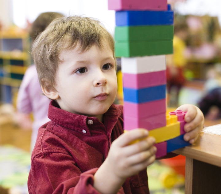 portrait of little cute boy making towel with lego