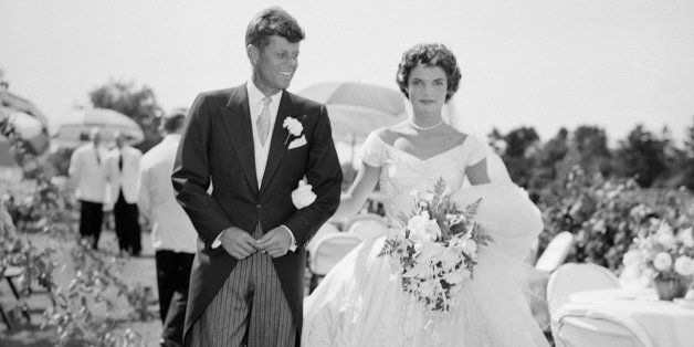 A scene from the Kennedy-Bouvier wedding. Groom John walks alongside his bride Jacqueline at an outdoor reception, 1953. Newport, Rhode Island. (Photo by Bachrach/Getty Images)