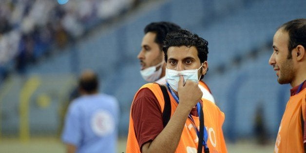 Saudi photographers wear mouth and nose masks during a football match at the King Fahad stadium, on April 22, 2014 in Riyadh. The health ministry reported more MERS cases in the city of Jeddah, prompting authorities to close the emergency department at the city's King Fahd Hospital. The ministry said it has registered 261 cases of infection across the kingdom since the discovery of the Middle East Respiratory Syndrome in September 2012. AFP PHOTO/FAYEZ NURELDINE (Photo credit should read FAYEZ NURELDINE/AFP/Getty Images)