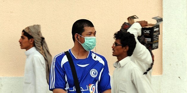 A foreign worker living in Riyadh wears a mask covering his mouth and nose on a main street in the Saudi capital on April 29, 2014 as the death toll from the newly emerged and often fatal Middle East Respiratory Syndrome (MERS) disease topped 100 in the desert kingdom. The health ministry reported more MERS cases in the city of Jeddah, prompting authorities to close the emergency department at the city's King Fahd Hospital. AFP PHOTO/FAYEZ NURELDINE (Photo credit should read FAYEZ NURELDINE/AFP/Getty Images)