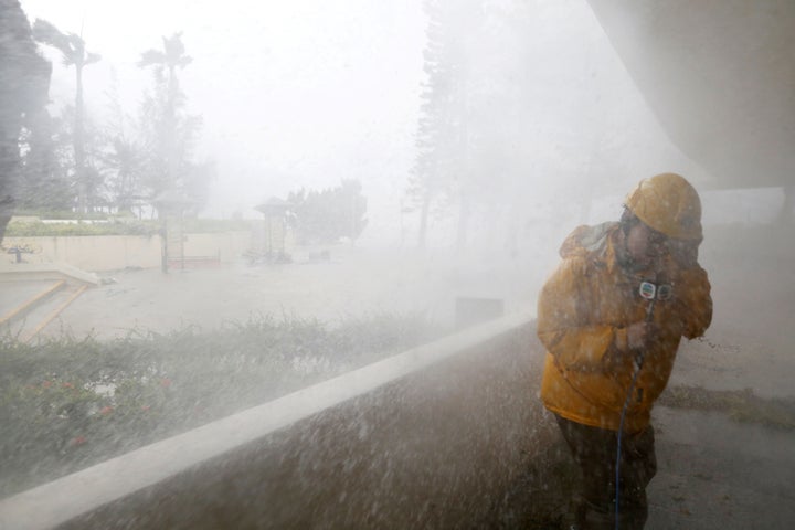 A journalist braves high waves near the Hong Kong waterfront on Sunday.