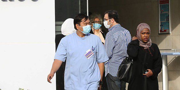 Medical workers and foreigners wear a mouth and nose mask as they leave a local hospital's emergency department, on April 22, 2014 in the Red Sea coastal city of Jeddah. The health ministry reported more MERS cases in Jeddah, prompting authorities to close the emergency department at the city's King Fahd Hospital. The ministry said it has registered 261 cases of infection across the kingdom since the discovery of the Middle East Respiratory Syndrome in September 2012. AFP PHOTO/STR (Photo credit should read -/AFP/Getty Images)