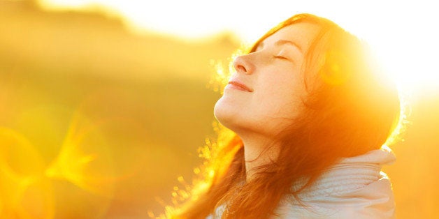 Young woman enjoying sunlight. Natural sun and optical flare. The concept of freedom and healthy lifestyle